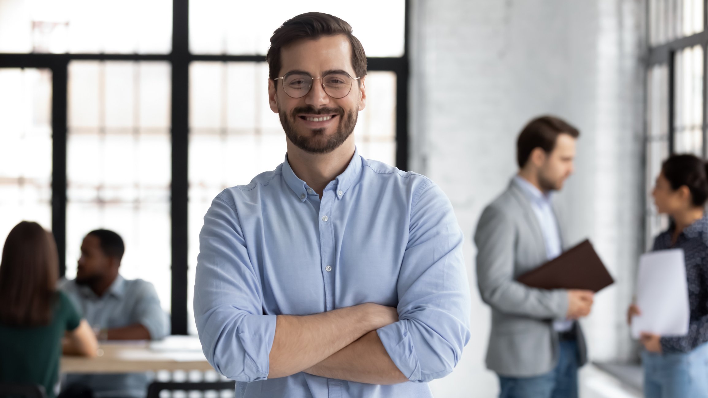 Smiling male CEO posing alone in modern office